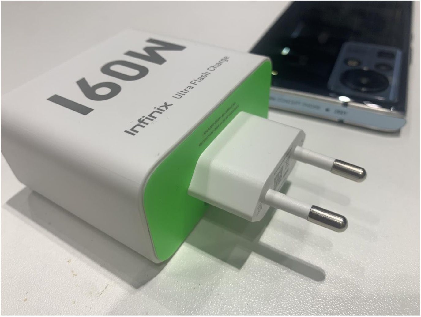 Infinix 160W Charger with Infinix Zero X in the background 