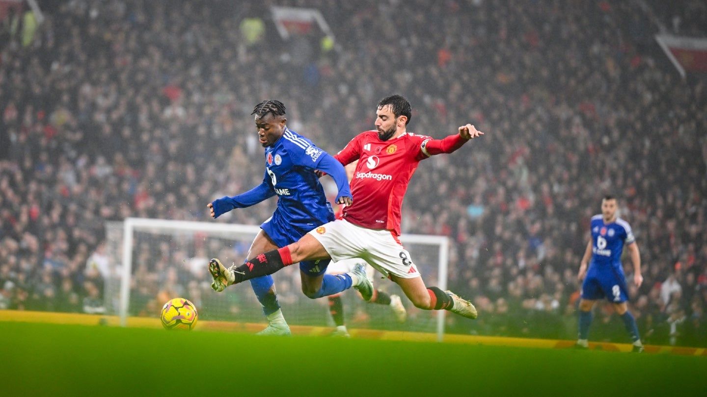 Close-up of hands holding a smartphone displaying a live Premier League football match on screen, illustrating mobile streaming.