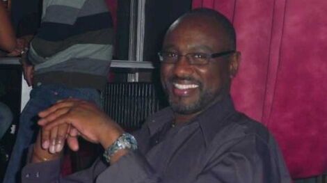 Robert Kirubi smiling as a picture is taken of him.
