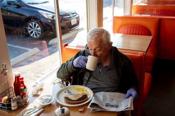 Restaurants and other businesses in California that suffered under pandemic restrictions were allowed to return to full capacity on Tuesday. Ralph Kottke read a newspaper over breakfast in Los Angeles on Tuesday.