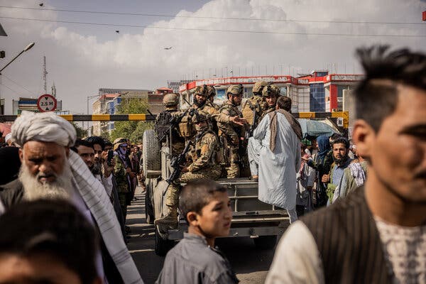A U.S. Air Force transport plane flying by in the distance as a Taliban elite unit drove on the streets in Kabul, Afghanistan, on Friday.