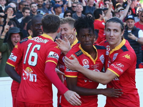Bruce Kamau celebrating with his teammates after a team goal.