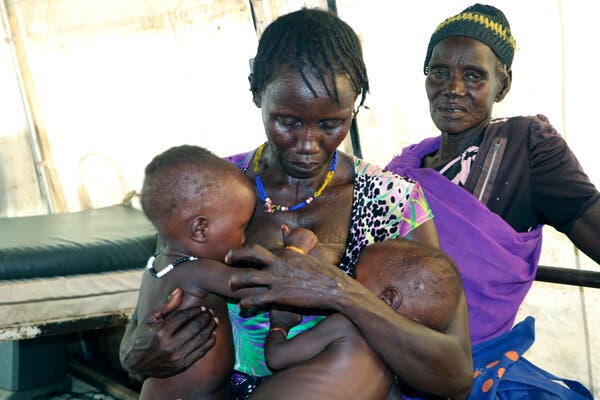 A woman with her twins in a health clinic in South Sudan, where tens of thousands of people are suffering famine.