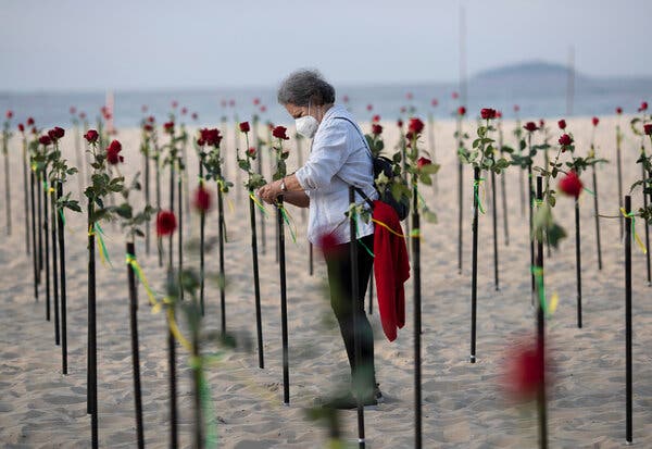A woman placed a rose in the sand on Copacabana beach in Rio de Janeiro on Sunday, in memory of Brazil’s 500,000 coronavirus deaths.