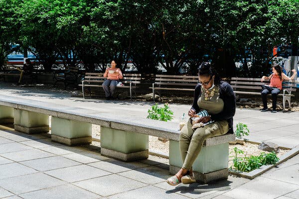 People ate lunch alone in a Manhattan plaza last month. Feelings of loneliness increased during the pandemic, even as conditions that kept people apart improved.