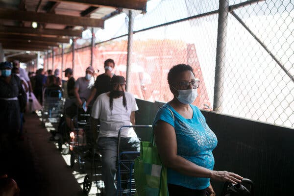 Waiting for food distribution in Harlem last week. New York is among the states that have been approved for a short-term $300 weekly federal supplement to unemployment benefits.