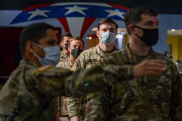 U.S. Army soldiers assigned to Ft. Bragg Army Post, N.C., wait to get vaccinated against the coronavirus.