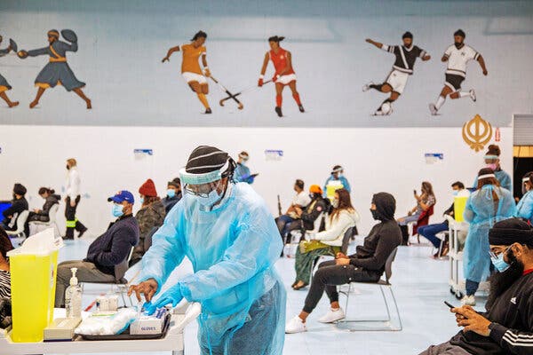 Health care workers administering the Pfizer-BioNTech vaccine at a Sikh house of worship in Mississauga, Ontario.