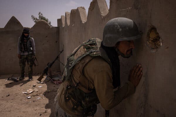 An Afghan National Army soldier looked through a hole in the wall during fighting in Lashkar Gah, Helmand, Afghanistan, last month.