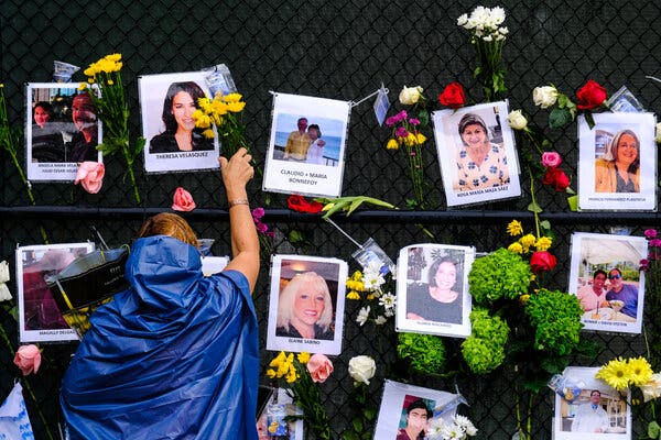 A woman placed flowers at a memorial for those missing in the building collapse at the Champlain South Towers in Surfside, Fla.
