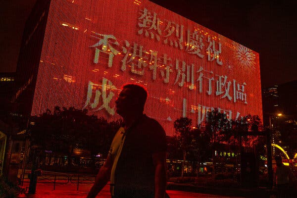 Banners display messages celebrating the centenary of the Chinese Community Party and the anniversary of Hong Kong's handover to China atop a building in Hong Kong.