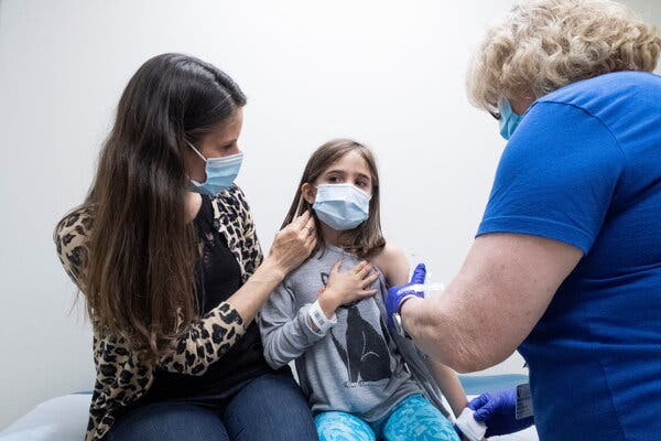 Marisol Gerardo, 9, is held by her mother as she gets a second dose of the Pfizer vaccine during a clinical trial for children at Duke Health in Durham, N.C., in April.
