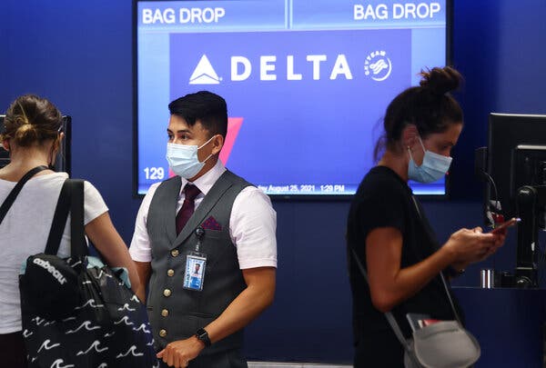 A Delta Air Lines employee helping travelers at Los Angeles International Airport in August.