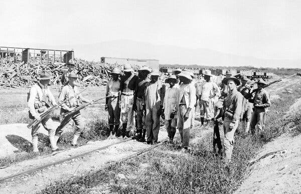 U.S. Marines guarding Haitians outside Port-au-Prince in February 1920. In 1915, President Woodrow Wilson sent the Marines to protect U.S. interests after the assassination of the Haitian president.
