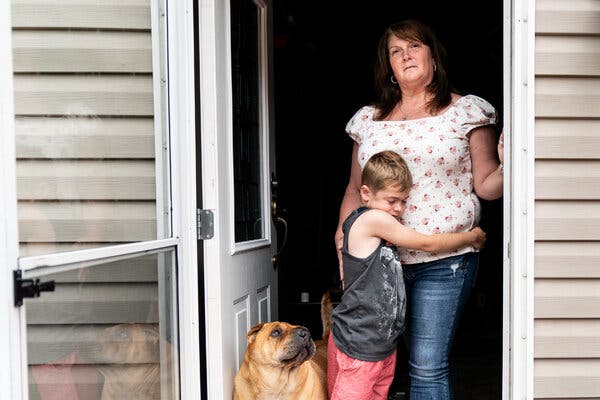 David Austin hugged his mother, Kimberly Burnworth, in the doorway of their mobile home in Bruceton Mills, W.Va., this month.
