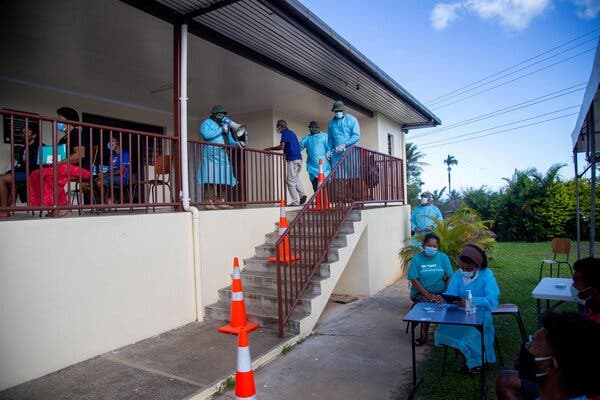 A health officer directed residents for coronavirus testing in Suva, Fiji, in June. Daily reports of confirmed Covid cases have rocketed upward in recent weeks.