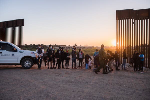 A U.S. Border Patrol agent questioning undocumented migrants from Cuba, Honduras, Nicaragua and Guatemala who walked towards the opening of the border wall in Yuma, Ariz., this month.