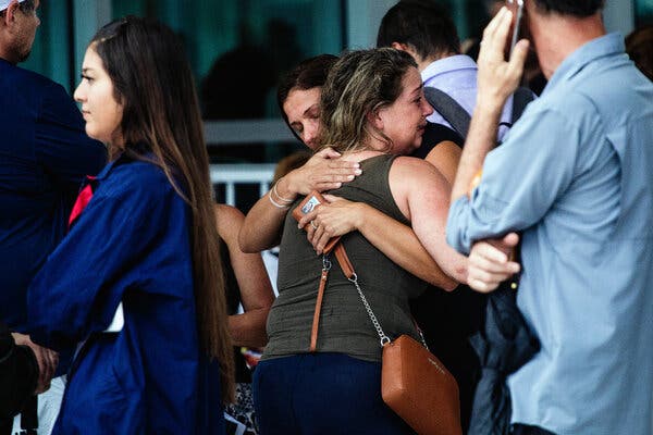 People gather at the Surfside Community Center as they wait to hear information on Thursday in Surfside, Fla.