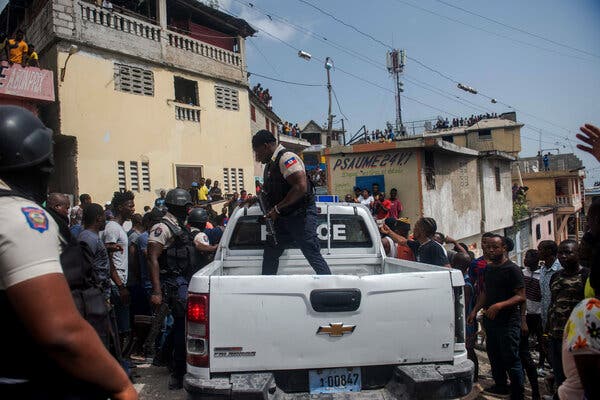 A crowd surrounded a police vehicle carrying two suspects in Port-au-Prince on Thursday.
