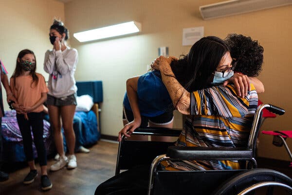 Aurora Duran, 86, is hugged by her granddaughter during a visit from her family at a long-term-care nursing community in Fort Stockton, Tex.. in April.