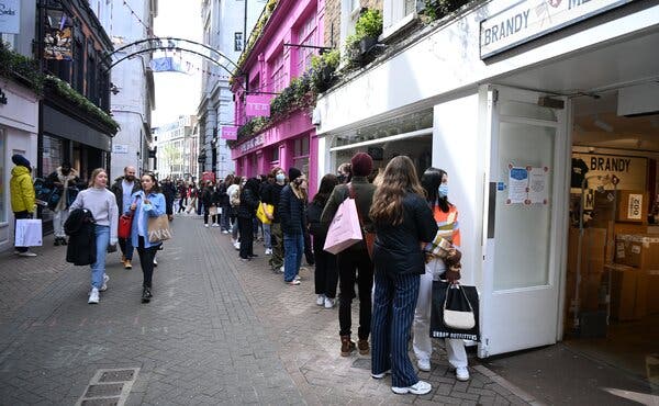 Shoppers outside stores in London in April, when lockdowns eased. Employers competing to fill jobs have helped cause Britain’s unemployment rate to slip lower in the second quarter.
