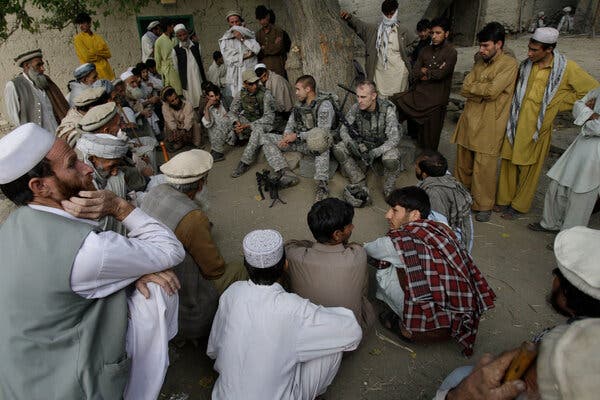 U.S. soldiers spoke with villagers through an interpreter in Afghanistan’s Kunar Province in 2009. More than 18,000 Afghans who assisted the United States during the war have been trapped in bureaucratic limbo after applying for special immigrant visas.