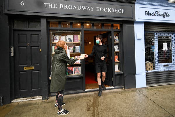 Handing off an order to a customer outside a bookshop in London, last month. The economic outlook for the rest of this year in Britain remains bleak.