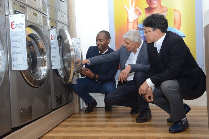 LG (L-R) Brian Gacheru CEO Pristine Linen & Laundry Ltd, Shailesh Kanani MD Hotpoint Appliances Ltd and LG East Africa Home Appliances Product Manager Mr. Eden Seo during the launch of a new smart laundry shop at the Thika Road Mall (TRM) in Nairobi. LG will partner with vendors and local entrepreneurs to roll out commercial machine reference stores as it seeks to tap into the fast-growing on-demand laundry market in East Africa.