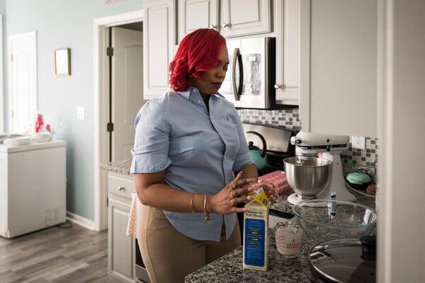 Anique Houpe bakes cakes and cupcakes in her kitchen for her startup business, The Munchie Shopp Bakery, in Stone Mountain, Ga., in March.