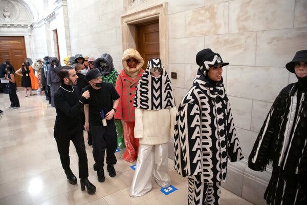 Marc Jacobs backstage at his spring 2022 show at the New York Public Library, amid a line-up of major Marc Jacobs print outerwear.