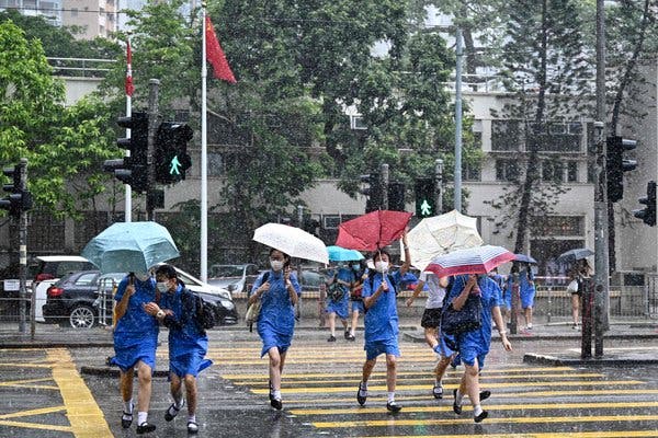 Students running for shelter during a sudden but brief heavy downpour in Hong Kong this week. Asian markets seemed to be worried about the spread of the coronavirus, after Hong Kong authorities reported another increase in cases that have forced the closure of school.
