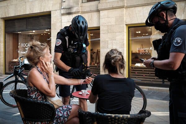 Checking health passes at a bar in Bordeaux, France, on Wednesday. Certification is needed to gain access to many public spaces and services in the country, including nonemergency hospital treatment.