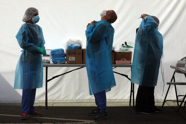 Clinicians suiting up at a free Covid-19 testing site in Oakland, Calif. Fewer Covid-related medical services will be free in the future.
