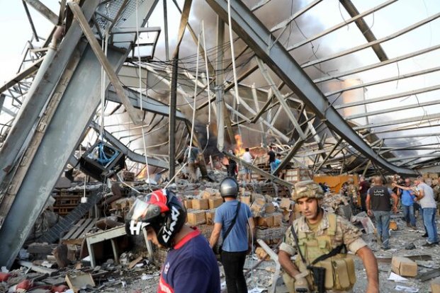 Emergency workers and civilians at the site of the explosion in Beirut on Tuesday.