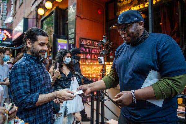 A bouncer at The Comedy Cellar in the West Village checks vaccine cards before a show in June.