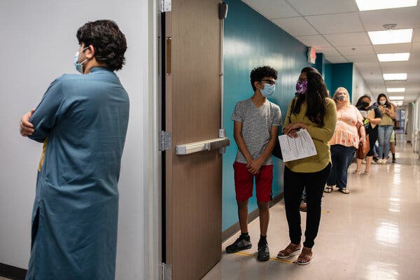 Waiting to be vaccinated in San Antonio this month. Some coronavirus patients and their families have been left mired in debt despite rules meant to protect them from exorbitant health care costs.