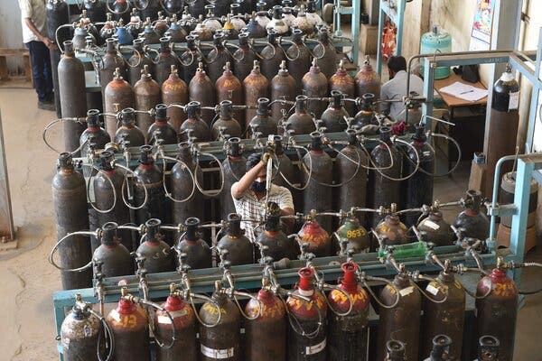 Technicians monitor the refilling of medical oxygen containers at a supply plant in Ahmedabad, India, on Monday.