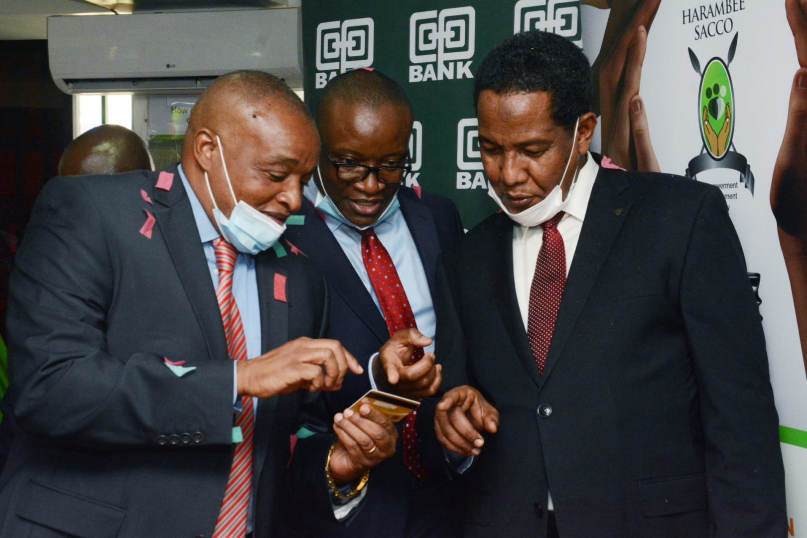 (L-R) The Chairman Harambee Sacco Macloud Malonza, the Director Cooperatives Banking at Co-op Bank Vincent Marangu and Principal Secretary, State Department for Cooperatives Ali Noor Ismail having a touch and feel at the very first debit card printed and issued instantly at the Sacco - Bizna