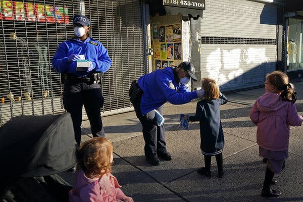 N.Y.P.D. community police officers hand out masks to passers-by in Brooklyn.