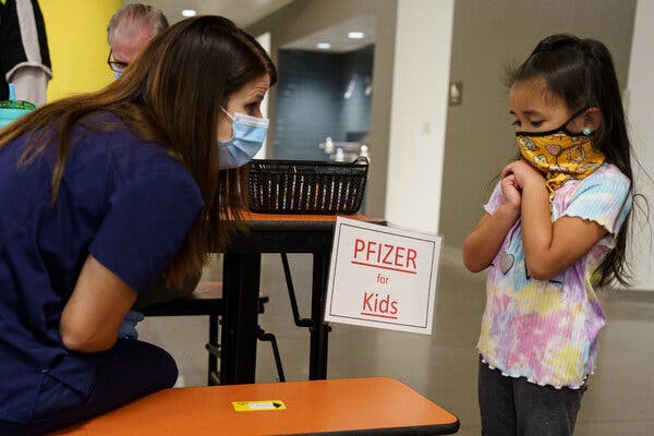 Mila Pagador, 5, speaking to registered nurse Ashley Bean before she received her dose of the Pfizer-BioNTech Covid-19 vaccine in Albuquerque, N.M., last year.