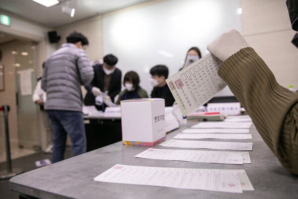 A voter checking his ID card before casting a ballot at a polling station in Seoul on Wednesday.