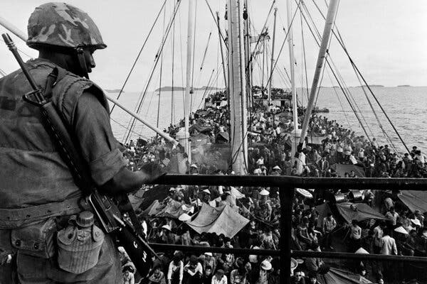 An American soldier watched as refugees boarded a Navy ship off the coast of Vietnam in May 1975.