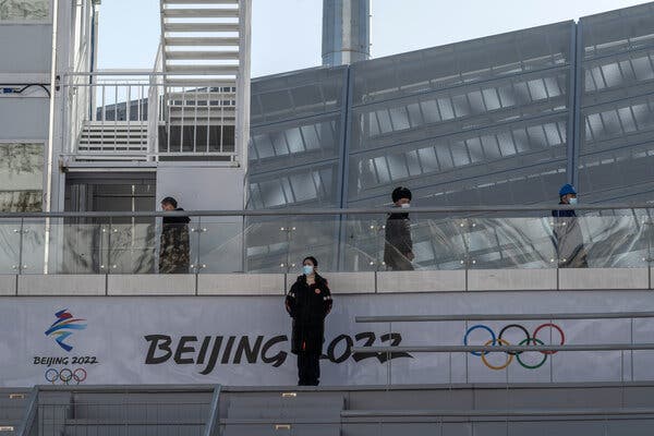 Olympic workers on Tuesday near the National Ski Jumping Center in Zhangjiakou, China. During the Games, waiters, cleaners and other support staff will not be allowed to leave venues to visit their families.