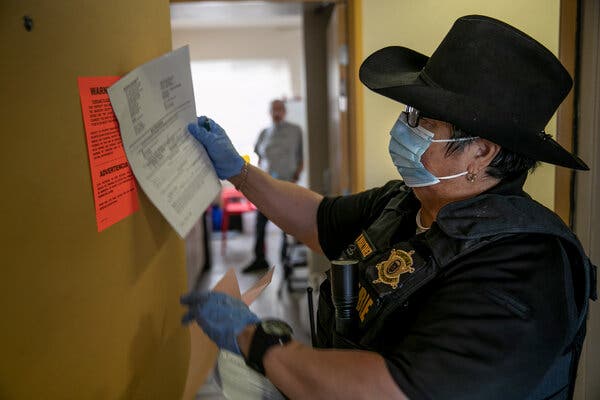 A Maricopa County constable posting an eviction order for non-payment of rent last October in Phoenix.