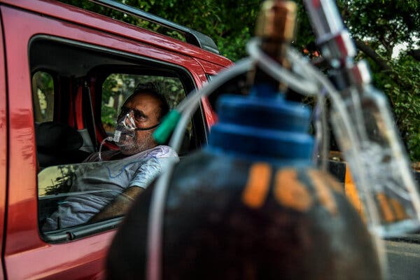 A patient receives oxygen inside a car in Delhi.