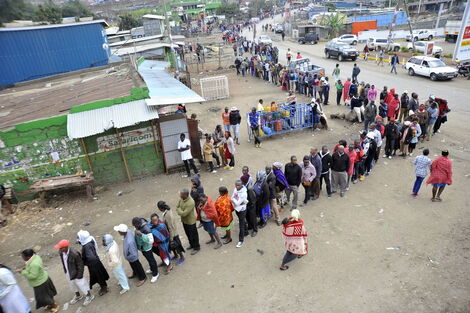 An image of people queuing up to vote