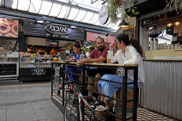 Drinking coffee at a market in Jerusalem on Tuesday after Israel eased coronavirus restrictions.