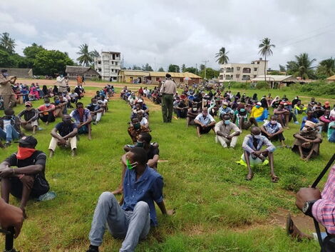 A police officer inspect youth awaiting to be listed under the Kazi Mtaani program phase 1.