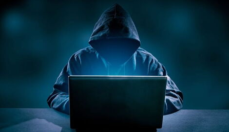 An image of an individual with a hidden face working on a computer taken on March 13, 2020