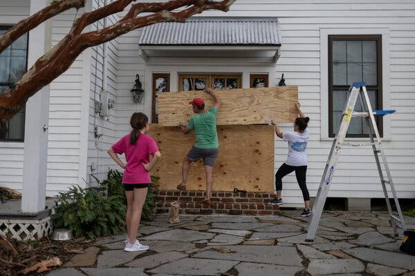 A family boarded up an entrance to their home in Morgan City, La., on Saturday. Some who did not evacuate as Hurricane Ida approached were regretting their choice to stay.